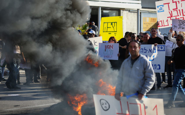 Les employés de l'entreprise Teva protestent contre le plan de licenciement de l'entreprise de centaines d'employés, aux abords du bâtiment de TEVA Pharmaceutical Industries à Ashdod, le 17 décembre 2017 (Crédit : Flash90)
