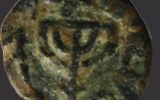 Au centre d'une pièce musulmane frappée à Jérusalem de la période des Omeyyades, au 8ème siècle, une ménorah à cinq branches. D'un côté, l'inscription "il n'y a d'autre Dieu qu'Allah". De l'autre, l'inscription en Arabe "Mahomet est le messager de Dieu". (Autorisation : Assaf Avraham)