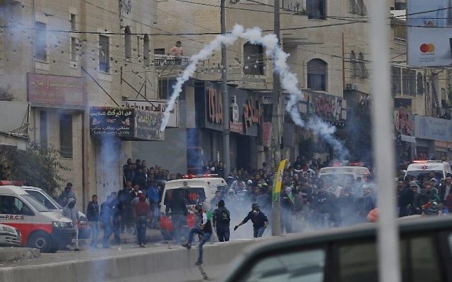 Des manifestants palestiniens affrontent les forces de l’ordre israéliennes près du checkpoint de Qalandiya, en Cisjordanie, le 20 décembre 2017, après la reconnaissance de Jérusalem comme capitale d’Israël par Donald Trump. (Crédit : AFP / ABBAS MOMANI)