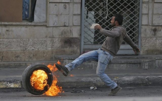 Des manifestants palestiniens affrontent les forces de l'ordre israéliennes près du checkpoint de Qalandiya, en Cisjordanie, le 20 décembre 2017, après la reconnaissance de Jérusalem comme capitale d'Israël par Donald Trump. (Crédit : AFP / ABBAS MOMANI)