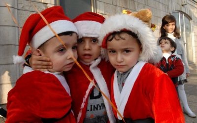 Des enfants arabo-israéliens participent à une célébration de Noël à la sortie de l'église de l'Annonciation dans la ville israélienne de Nazareth, au nord du pays, là où les chrétiens estiment que l'ange Gabriel a dit à Marie qu'elle allait donner naissance à Jésus-Christ. 24 décembre 2009. (Gili Yaari / FLASH90)