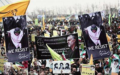 Des manifestants iraniens tiennent un portrait du général de division Qassem Soleimani, commandant des forces al-Quds des gardiens de la révolution iranienne et une personnalité centrale dans la propagation violente de la révolution iranienne. Photo prise place Azadi à Téhéran le 11 février 2015 (Crédit : Behrouz Mehri/AFP)