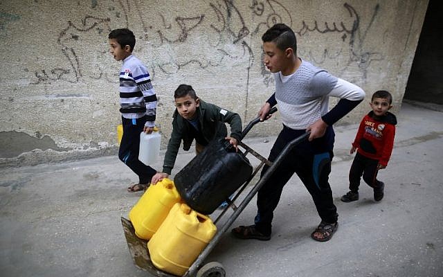 Des enfants palestiniens transportent des bidons d'eau dans le camp de réfugiés d'al-Shati dans la ville de Gaza le 4 janvier 2018 (Crédit : AFP PHOTO / MOHAMMED ABED) Des enfants palestiniens transportent des bidons d'eau dans le camp de réfugiés d'al-Shati dans la ville de Gaza le 4 janvier 2018 (Crédit : AFP PHOTO / MOHAMMED ABED)