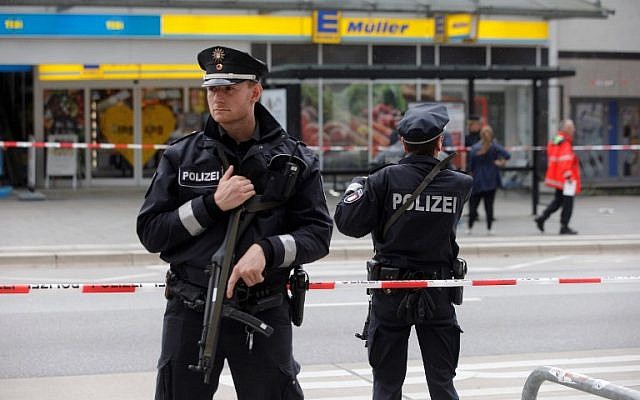 Des policiers montent la garde devant un supermarché à Hambourg, en Allemagne, où un homme a tué une personne et en a blessé six autres lors d'une attaque au couteau, le 28 juillet 2017 (Crédit : AFP / DPA / Markus Scholz)