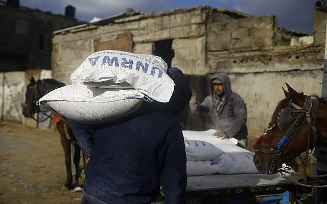 Des Palestiniens chargent un cheval avec des sac de denrées alimentaires fournies par l'UNRWA, à Gaza City, le 15 janvier 2018. (Crédit : AFP / MOHAMMED ABED) Des Palestiniens chargent un cheval avec des sac de denrées alimentaires fournies par l'UNRWA, à Gaza City, le 15 janvier 2018. (Crédit : AFP / MOHAMMED ABED)