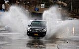 Les automobilistes conduisent à travers les rues inondées après une tempête hivernale qui a frappé la ville côtière de Netanya, au nord de Tel Aviv, le 25 janvier 2018 (Crédit : JACK GUEZ / AFP)