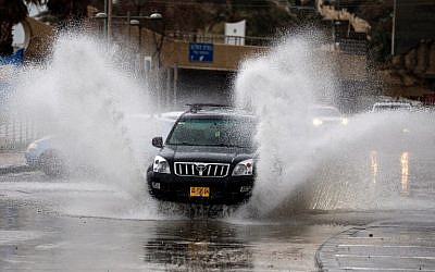 Les automobilistes conduisent à travers les rues inondées après une tempête hivernale qui a frappé la ville côtière de Netanya, au nord de Tel Aviv, le 25 janvier 2018 (Crédit : JACK GUEZ / AFP)