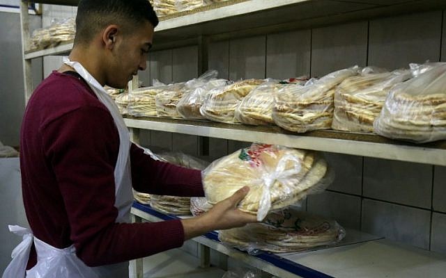 Un ouvrier jordanien emballe du pain dans une boulangerie de la capitale jordanienne Amman le 27 janvier 2018. (AFP / Khalil MAZRAAWI) Un ouvrier jordanien emballe du pain dans une boulangerie de la capitale jordanienne Amman le 27 janvier 2018. (AFP / Khalil MAZRAAWI)