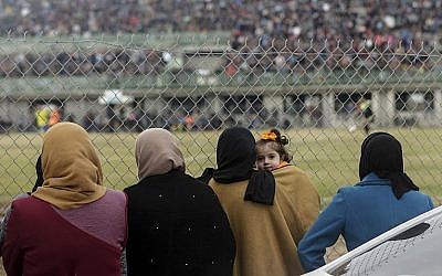 Des Palestiniennes assistent au match de football entre Al-Nuseirat et Al-Jalaa devant la clôture du stade du camp de réfugiés de Nuseirat, au sud de la ville de Gaza, le 28 janvier 2018 (AFP PHOTO / MAHMUD HAMS)