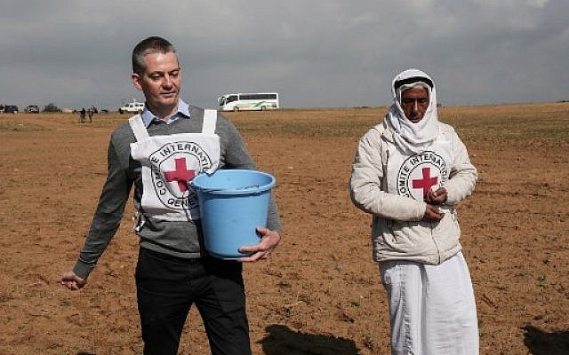 Guislain Defurne (à gauche), chef de la sous-délégation du Comité international de la Croix-Rouge (CICR) à Gaza, aide un agriculteur palestinien à semer des graines dans un champ, à l'est de Rafah, le 29 janvier 2018 (DIT KHATIB / AFP) Guislain Defurne (à gauche), chef de la sous-délégation du Comité international de la Croix-Rouge (CICR) à Gaza, aide un agriculteur palestinien à semer des graines dans un champ, à l'est de Rafah, le 29 janvier 2018 (DIT KHATIB / AFP)