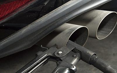 Un tuyau fixé au pot d'échappement d'une Golf Volkswagen diesel pour un test d'émission de gaz à  Ludwigsburg, dans le sud de l'Allemagne, le 7 août 2017 (Crédit : AFP PHOTO / THOMAS KIENZLE)