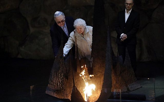 Alicja Mularska (C), la fille du défunt couple polonais Jan Dziadosz et Sabina Perzyna ranime la flamme éternelle après avoir reçu la citation de Juste parmi les Nations au nom de ses parents lors d'une cérémonie posthume les honorant ainsi que leur fils Aleksandr Dziadosz au mémorial de Yad Vashem, le Centre Mondial de la Mémoire de l'Holocauste, à Jérusalem, le 30 janvier 2018. (Crédit : AFP / THOMAS COEX) Alicja Mularska (C), la fille du défunt couple polonais Jan Dziadosz et Sabina Perzyna ranime la flamme éternelle après avoir reçu la citation de Juste parmi les Nations au nom de ses parents lors d'une cérémonie posthume les honorant ainsi que leur fils Aleksandr Dziadosz au mémorial de Yad Vashem, le Centre Mondial de la Mémoire de l'Holocauste, à Jérusalem, le 30 janvier 2018. (Crédit : AFP / THOMAS COEX)