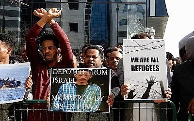 Les amis de Tesfe Kidane (aucun lien avec Helen Kidane), un demandeur d'asile érythréen déporté au Rwanda il y a deux ans, brandissent sa photo lors d'une manifestation devant l'ambassade rwandaise à Herzliya le 22 janvier 2018. Kidane a été assassiné en Libye en essayant de fuir vers l'Europe. (Melanie Lidman / Times of Israël)