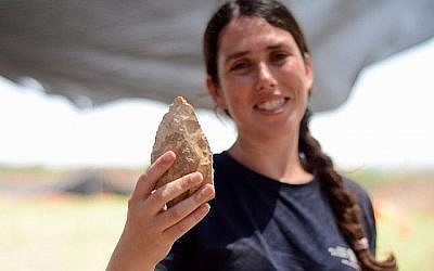 Maayan Shemer, directrice des fouilles pour l'Autorité israélienne des Antiquités, montre une hache taillée à la main d'un demi-million d'années à Jaljulia. (Crédit : Samuel Magal, autorisation AIA)