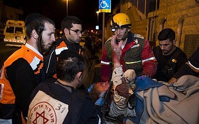 Personnel de secours et infirmier, y compris des paramédicaux ultra-orthodoxes, transportant une femme blessée sur les lieux de l'effondrement du dernier étage d'un bâtiment après l'explosion d'un réservoir d'essence dans le quartier de Gilo, Jérusalem, 20 janvier 2014. (Yonatan Sindel / Flash90)