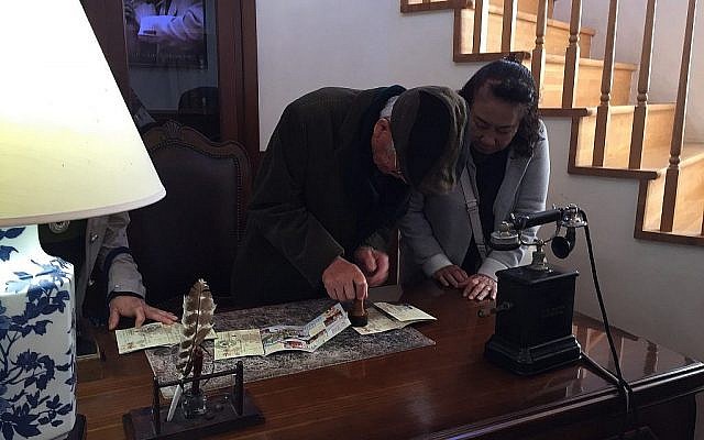 A Yaotsu, au Japon, en novembre 2010, des visiteurs japonais estampillent un passeport avec 'l'estampille de Sugihara' au musée du mémorial Sugihara (Crédit : Amanda Borschel-Dan/Times of Israel)