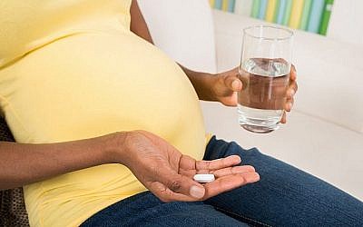 Photo illustrative de femme enceinte prenant une pilule. (Andrey Popov / Images iStock, Getty Images)