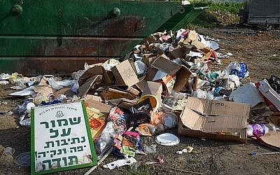 Un tas d'ordures sous un panneau qui demande aux gens de s'abstenir de jeter des déchets (Crédit : Autorisation Yael Argov)
