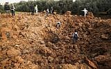 Les Palestiniens inspectent le site d'une frappe aérienne israélienne à Gaza le 18 février 2018 (Crédit : AFP / MAHMUD HAMS)