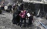 Une femme et des enfants syriens courent se réfugier parmi les décombres de bâtiments après l'attentat à la bombe perpétré par le gouvernement dans la ville rebelle de Hamouria, dans la région assiégée de Ghouta Est, à la périphérie de la capitale Damas, le 19 février 2018. (AFP/Abdulmonam Eassa)