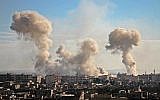 La fumée s'élève des bâtiments après le bombardement du village de Mesraba, dans la région assiégée de Ghouta Est, dans la banlieue de la capitale Damas, le 19 février 2018. (AFP PHOTO / Hamza Al-Ajweh)
