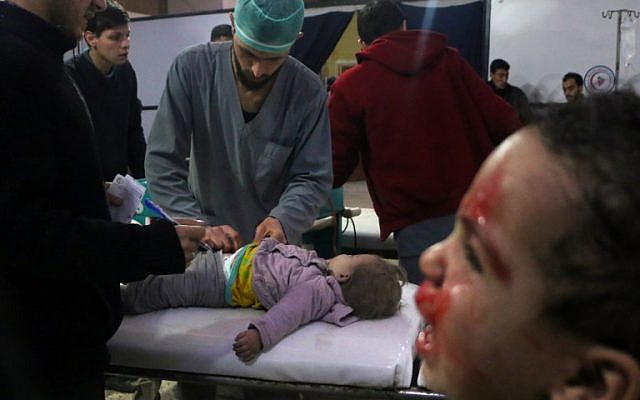 Les médecins syriens s'occupent d'un bébé, alors qu'un enfant pleure à côté d'eux dans une clinique de fortune après les bombardements du gouvernement syrien à Douma, dans la région assiégée de Ghouta Est, à la périphérie de la capitale Damas, le 22 février 2018. (AFP/Hamza Al-Ajweh) Les médecins syriens s'occupent d'un bébé, alors qu'un enfant pleure à côté d'eux dans une clinique de fortune après les bombardements du gouvernement syrien à Douma, dans la région assiégée de Ghouta Est, à la périphérie de la capitale Damas, le 22 février 2018. (AFP/Hamza Al-Ajweh)
