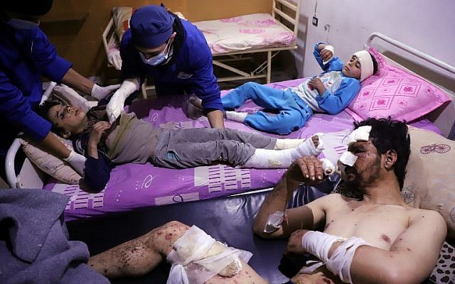 Les médecins soignent Omar, âgé de dix ans, qui a été blessé lors d'une frappe aérienne qui a tué plusieurs membres de sa famille dans leur maison d'Otaybah, dans l'enclave syrienne de Ghouta Est tenue par les rebelles, alors que son père et sa sœur de sept ans, Manar, le surveillent dans un hôpital de fortune le 25 février 2018. (AFP PHOTO / AMER ALMOHIBANY) Les médecins soignent Omar, âgé de dix ans, qui a été blessé lors d'une frappe aérienne qui a tué plusieurs membres de sa famille dans leur maison d'Otaybah, dans l'enclave syrienne de Ghouta Est tenue par les rebelles, alors que son père et sa sœur de sept ans, Manar, le surveillent dans un hôpital de fortune le 25 février 2018. (AFP PHOTO / AMER ALMOHIBANY)