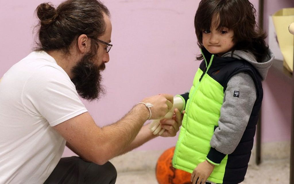 Une photo prise le 16 janvier 2018 montre Ruwayd, une enfant de trois ans, à qui l'on attache une prothèse imprimée en 3D à l'hôpital de chirurgie reconstructive de Médecins sans frontières (MSF) dans la capitale de la Jordanie, Amman (Crédit : AFP PHOTO / KHALIL MAZRAAWI) Une photo prise le 16 janvier 2018 montre Ruwayd, une enfant de trois ans, à qui l'on attache une prothèse imprimée en 3D à l'hôpital de chirurgie reconstructive de Médecins sans frontières (MSF) dans la capitale de la Jordanie, Amman (Crédit : AFP PHOTO / KHALIL MAZRAAWI)
