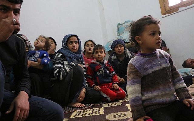 Des membres de sept familles syriennes déplacées réfugiés dans un appartement dans la ville syrienne d'Afrin, le 1er février 2018, dans le nord de la Syrie (Crédit : AFP / Ahmad Shafie BILAL) Des membres de sept familles syriennes déplacées réfugiés dans un appartement dans la ville syrienne d'Afrin, le 1er février 2018, dans le nord de la Syrie (Crédit : AFP / Ahmad Shafie BILAL)