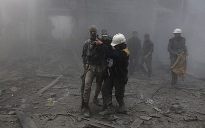 Un homme blessé reçoit de l'aide pour sortir des décombres après une frappe aérienne dans l'enclave rebelle d'Arbin, dans la Ghouta orientale, près de Damas, le 8 février 2018. (Crédit : AFP/ ABDULMONAM EASSA)