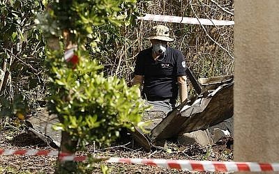 Une photo prise dans la vallée du Jezreel dans le nord d'Israël montre des spécialistes en explosifs en train d'inspecter des débris, le 10 février 2018 (Crédit : AFP PHOTO / Jack GUEZ)