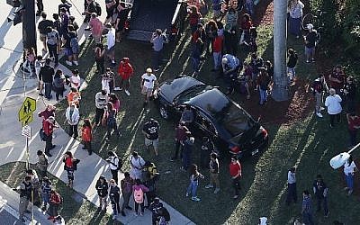 Les gens attendent leurs proches à la sortie du lycée Marjory Stoneman Douglas après une fusillade à l'école qui a fait plusieurs morts et blessés, le 14 février 2018 à Parkland, en Floride (Crédit : Joe Raedle / Getty Images / AFP)