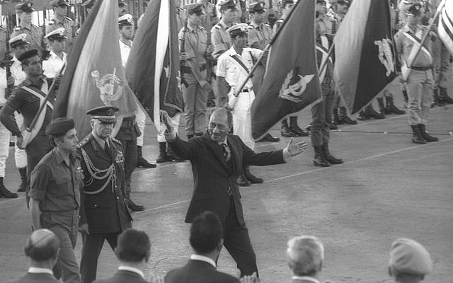 Le président égyptien Anouar el-Sadate salue les Israéliens avant de quitter l'aéroport Ben Gourion, le 21 novembre 1977 (archives Miki Tzarfati / GPO)