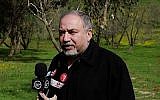 Le ministre de la Défense Avigdor Liberman parle à la presse dans un champ situé aux abords de la bande de Gaza le 20 février 2018 (Crédit :Judah Ari Gross/Times of Israel