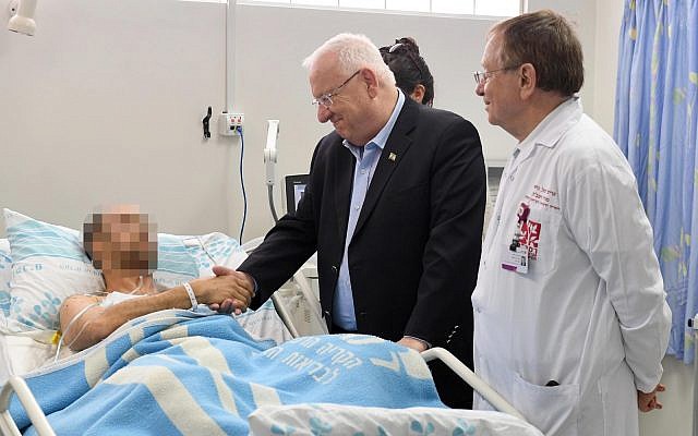 Le président Reuven Rivlin rend visite aux pilotes de l'armée israélienne blessés lors de leur éjection d'un F-16 israélien frappé par un tir anti-aérien syrien, le 11 février 2018 (Crédit : Mark Neiman/GPO)