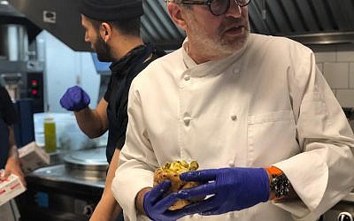 Le chef israélien Eyal Shani prépare une pita dans son nouveau restaurant de New York de la chaîne Miznon (Crédit : Danielle Ziri/Times of Israel)