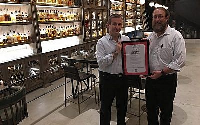 Le rabbin Aaron Leibowitz (à droite), présente un certificat de casheroute alternatif au Whisky Bar Museum au marché de Sarona à Tel-Aviv (Autorisation Hashgacha Pratit)