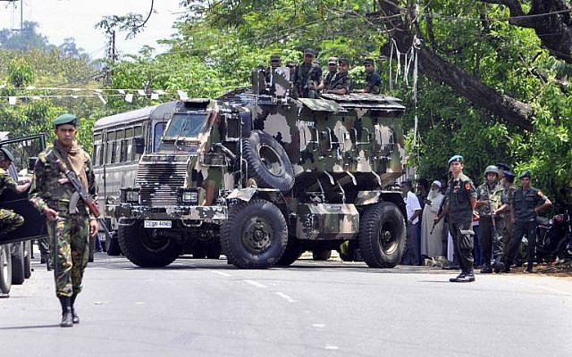 Les commandos de la police sri-lankaise patrouillent dans les rues de Pallekele, un quartier de Kndy, suite aux émeutes anti-musulmanes qui ont amené le gouvernement à déclarer l'état d'urgence, le 6 mars 2018 (Crédit : AFP)