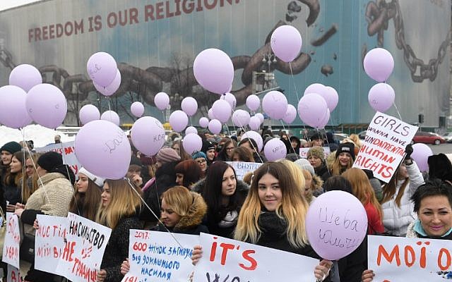 Des militantes brandissent des pancartes et des ballons pendant une marche féministe dans la ville ukrainienne de Kiev pour marquer la Journée internationale des droits des femmes, le 8 mars 2018 (Crédit : AFP/Sergei SUPINSKY) Des militantes brandissent des pancartes et des ballons pendant une marche féministe dans la ville ukrainienne de Kiev pour marquer la Journée internationale des droits des femmes, le 8 mars 2018 (Crédit : AFP/Sergei SUPINSKY)