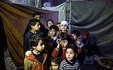 Les enfants syriens posent pour une photo dans un abri antiaérien artisanal dans la ville de Douma, détenue par les rebelles, dans la Ghouta orientale, située dans les faubourgs de  Damas, le 8 mars 2018 (Crédit : AFP PHOTO / HAMZA AL-AJWEH