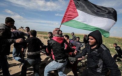Les Palestiniens aident à évacuer un manifestant blessé durant des affrontements avec les soldats israéliens près de Khan Yunis le long de la clôture frontalière entre Israël et le sud de la bande de Gaza, le 9 mars 2018 (Crédit :  AFP PHOTO / SAID KHATIB)