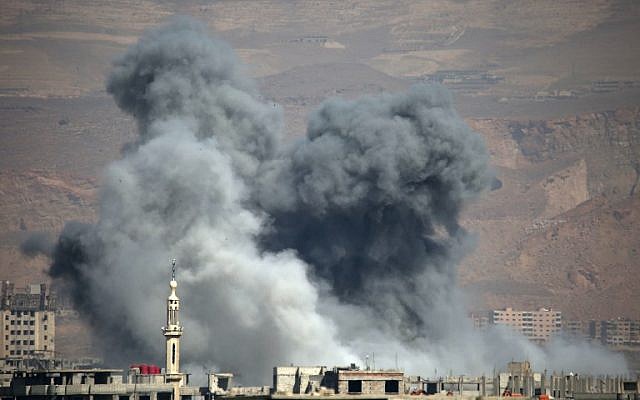 De la fumée s'élève suite aux bombardements du gouvernement dans la ville d'Arbin, contrôlée par les rebelles, dans l'enclave de la Ghouta orientale assiégée aux abords de la capitale de Damas le 11 mars 2018 (Crédit : / AFP PHOTO / Amer ALMOHIBANY)