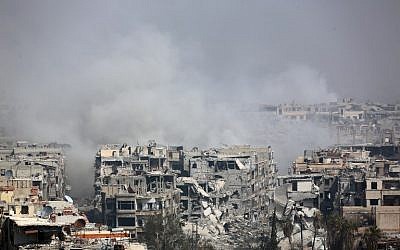 Illustration : De la fumée s’élevant suite aux bombardements du gouvernement syrien sur la ville assiégée par les rebelles de Harasta, dans la région de la Ghouta orientale, à la périphérie de Damas, le 12 mars 2018. (Crédit : AFP)