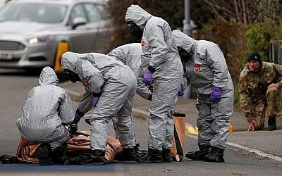 Des militaires britanniques portant une combinaison de protection travaillent pour évacuer un véhicule lié à l'attaque de l'agent neurotoxique du 4 mars à Salisbury, dans le sud-est de l'Angleterre, le 14 mars 2018. (Adrian DENNIS/AFP)