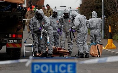 Des militaires britanniques portent des combinaisons de protection afin d’enlever un véhicule lié à l’empoisonnement du 4 mars à Salisbury (Crédit : AFP / ADRIAN DENNIS)