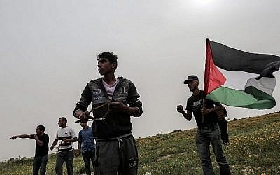 Un manifestant palestinien jette des pierres sur les soldats israéliens lors d'affrontements près de la frontière avec Israël à Khan Younès, dans le sud de la bande de Gaza, le 23 mars 2018. (AFP PHOTO / DIT KHATIB)