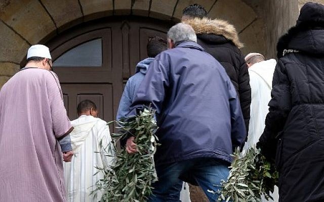 Des personnes portent des couronnes de rameaux d'olivier à l'église Saint Etienne de Trebes, dans le sud-ouest de la France, pour un service commémoratif le 25 mars 2018, deux jours après un attentat dans lequel quatre personnes ont été tuées (AFP PHOTO / ERIC CABANIS) Des personnes portent des couronnes de rameaux d'olivier à l'église Saint Etienne de Trebes, dans le sud-ouest de la France, pour un service commémoratif le 25 mars 2018, deux jours après un attentat dans lequel quatre personnes ont été tuées (AFP PHOTO / ERIC CABANIS)