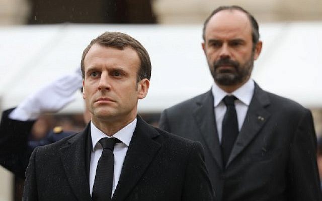 Emmanuel Macron, Édouard Philippe en arrière-plan à l'hommage national organisé par la France pour Arnaud Beltrame, mort en héros à Trèbes, le 28 mars 2018 (Crédit : AFP/MARIN/POOL)