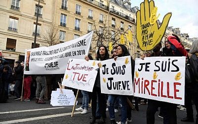Des politiciens et d'autres personnes se tiennent derrière des bannières alors qu'ils se préparent à participer à une marche blanche à Paris le 28 mars 2018, à la mémoire de Mireille Knoll, une femme juive de 85 ans assassinée chez elle.
(Crédit : AFP / ALAIN JOCARD)