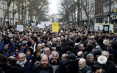 Les participants marchent derrière des banderoles tenant des pancartes lors d'une marche silencieuse à Paris en mémoire de Mireille Knoll, une Juive de 85 ans assassinée chez elle dans ce que la police a qualifié d'attaque antisémite (Crédit : François Guillot / AFP)